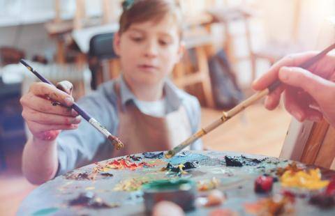 A child choosing colours for a painting.