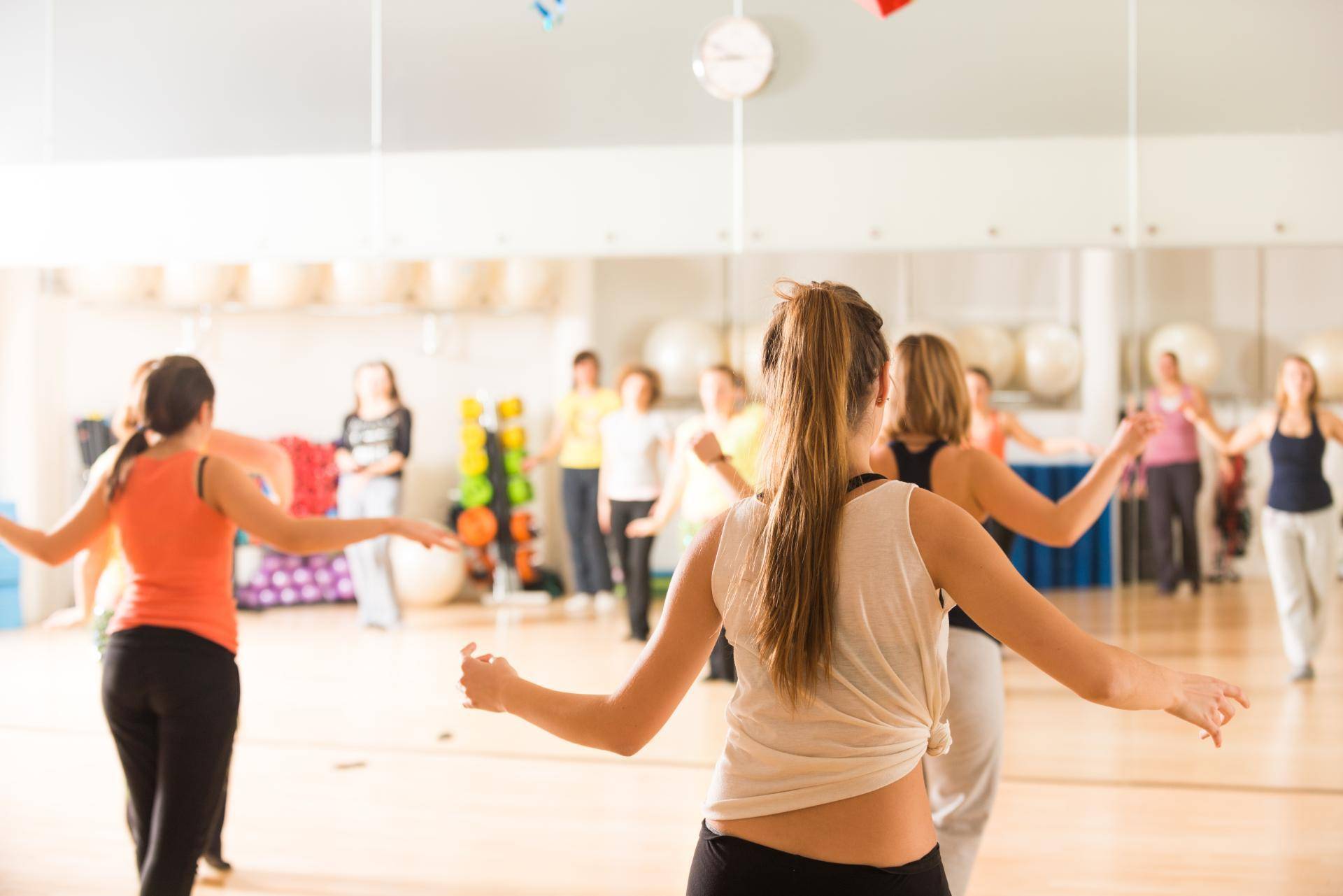 Group of young people practicing dance in a bright studio.
